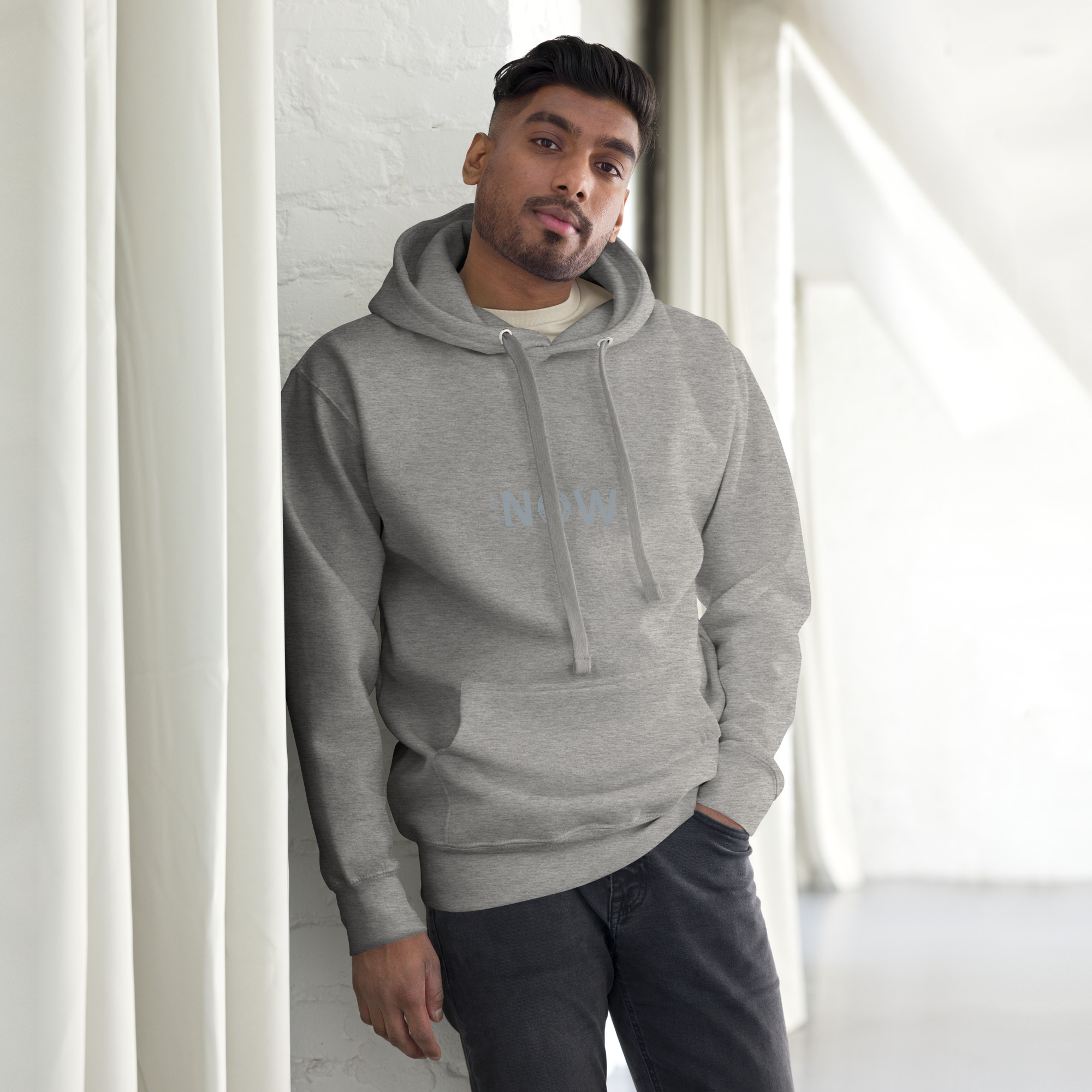 Hombre con sudadera gris de pie en el interior