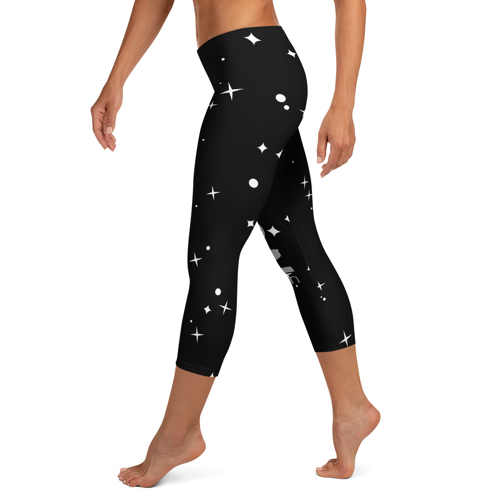 Femme portant un legging noir à motifs célestes.
