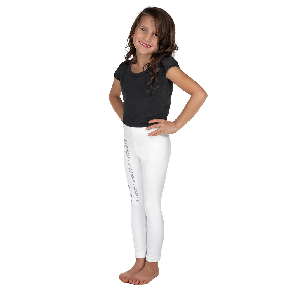 Ragazza sorridente in posa con camicia nera e leggings bianchi.